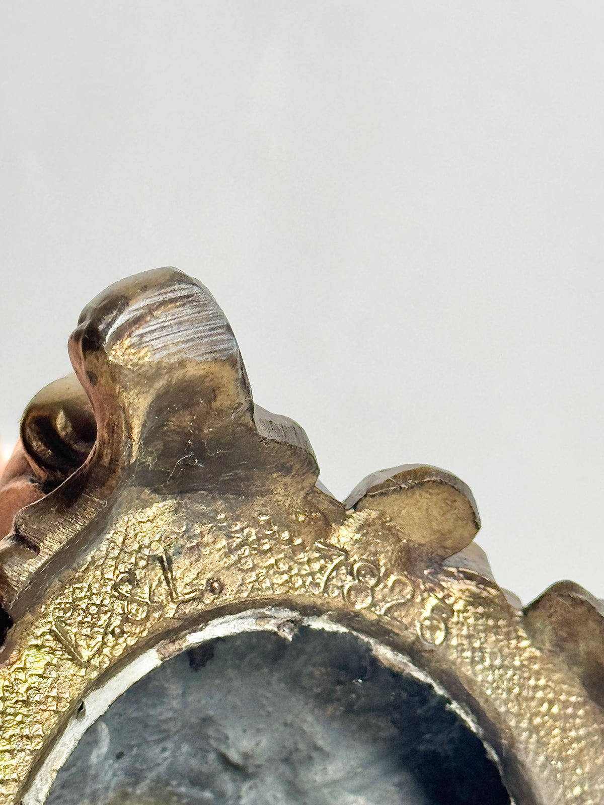 Close-up of the scrolled metal detailing on the crystal box base