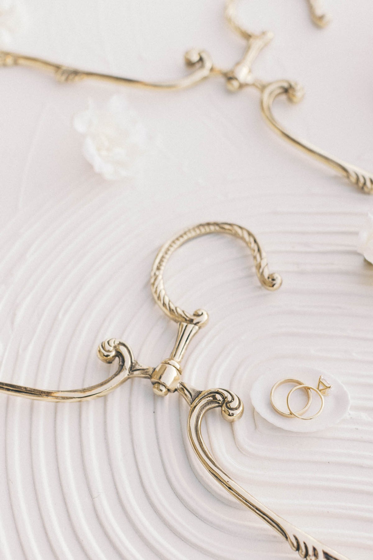 Gold-tone swivel hanger on a textured white backdrop