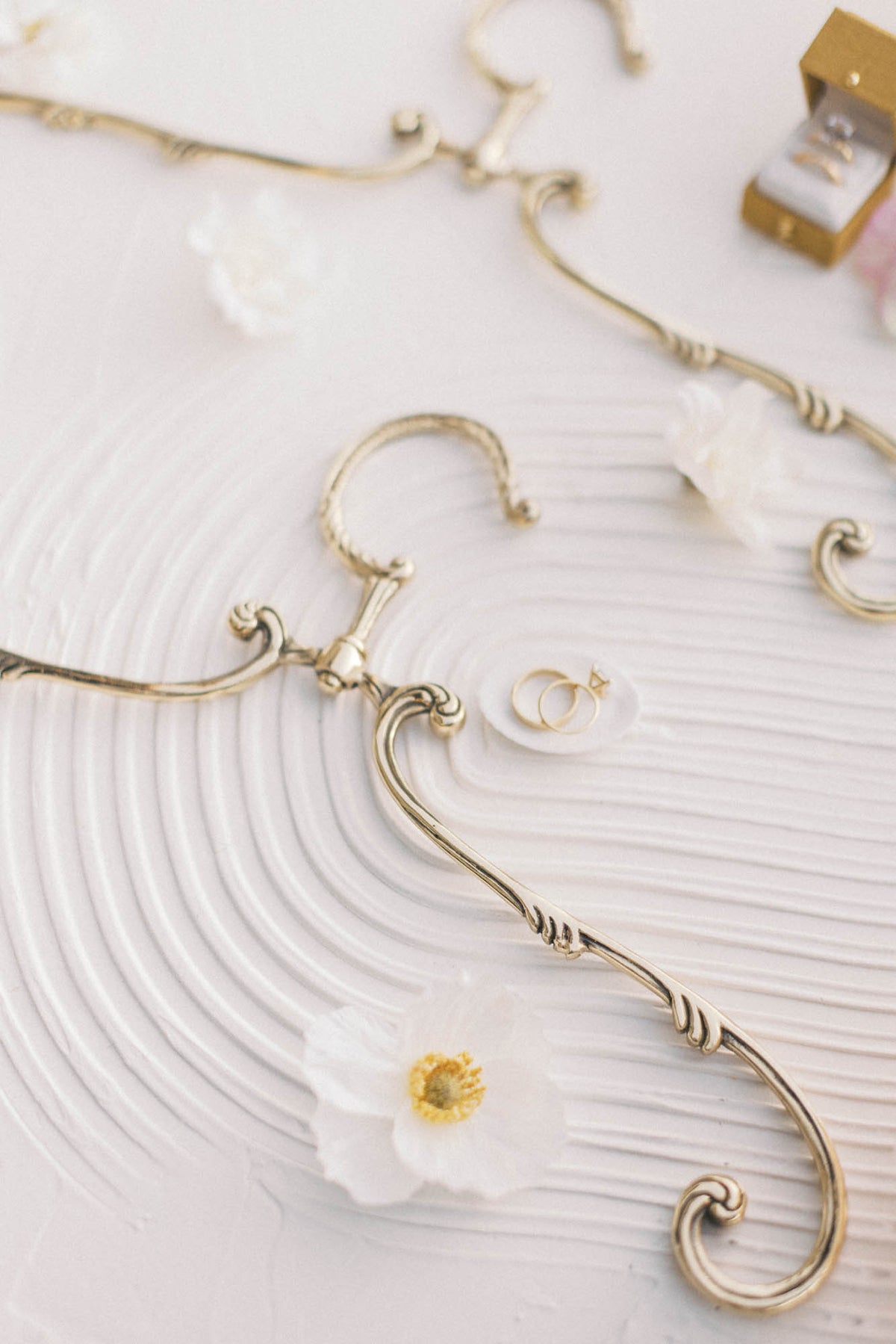 Vintage swivel hanger with a white flower on textured white
