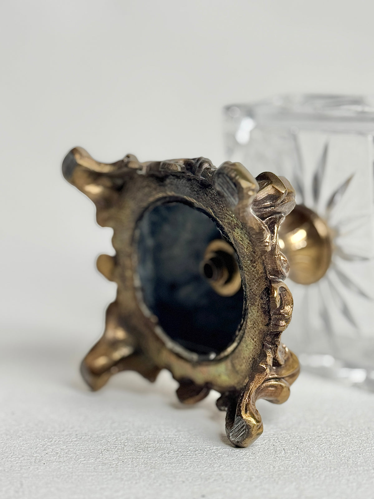 Underside of the ornate metal base of the vintage crystal box