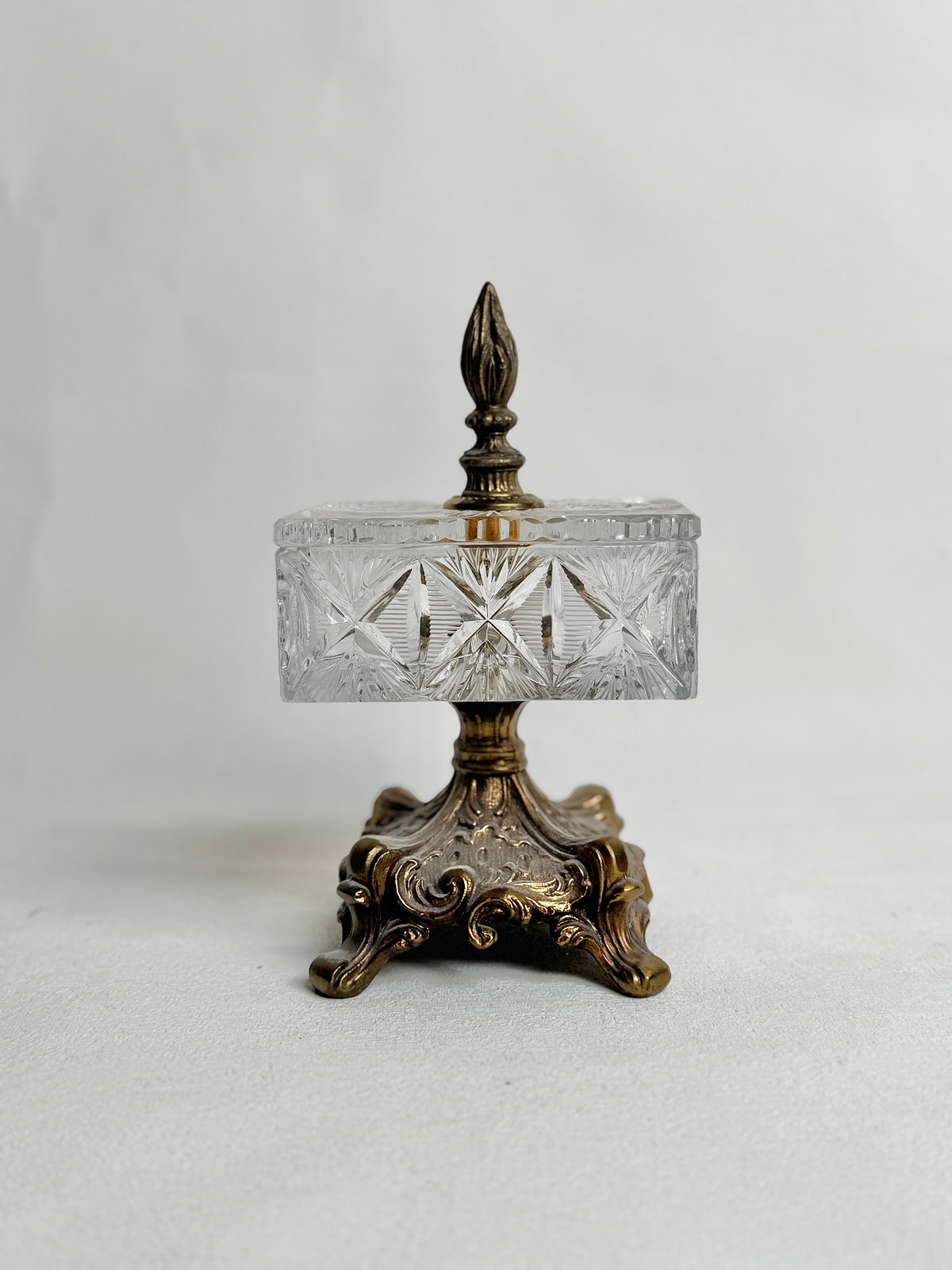 Vintage cut glass crystal pedestal box with an ornate metal base and finial