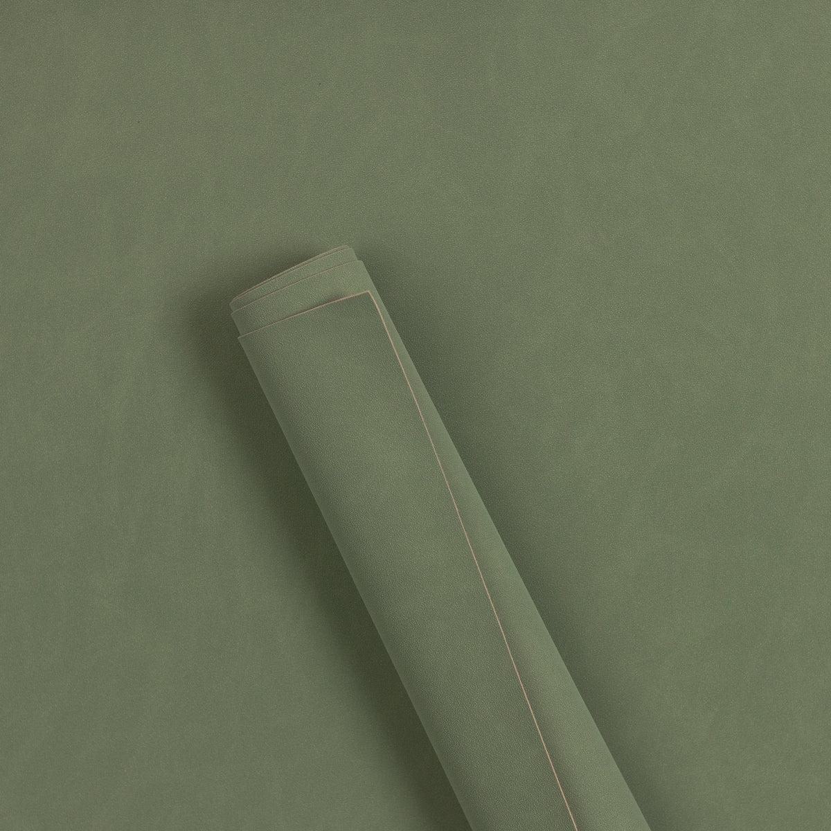 Sage green suede rollable styling mat, partly rolled