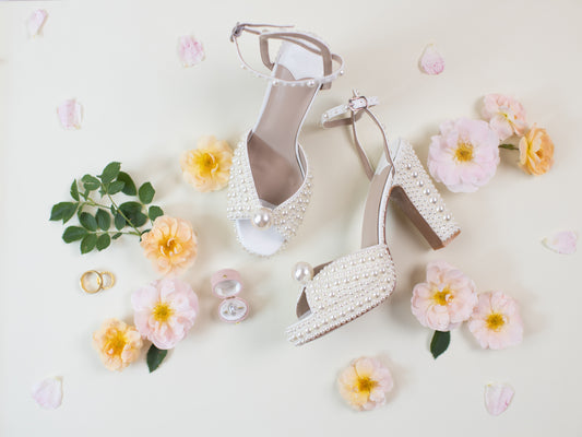 Bridal heels and florals styled on an ivory suede styling mat