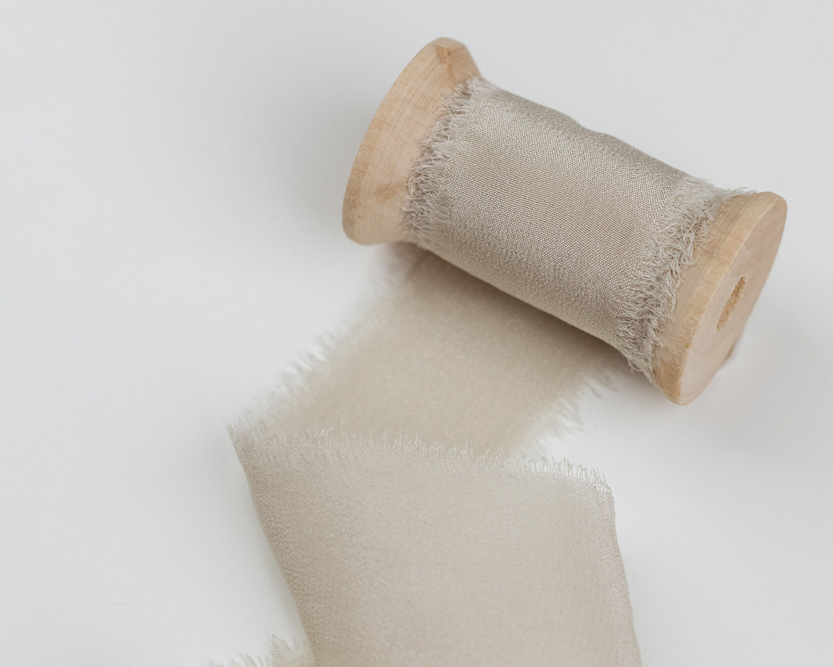 Close-up of Fawn taupe silk ribbon on a wooden spool