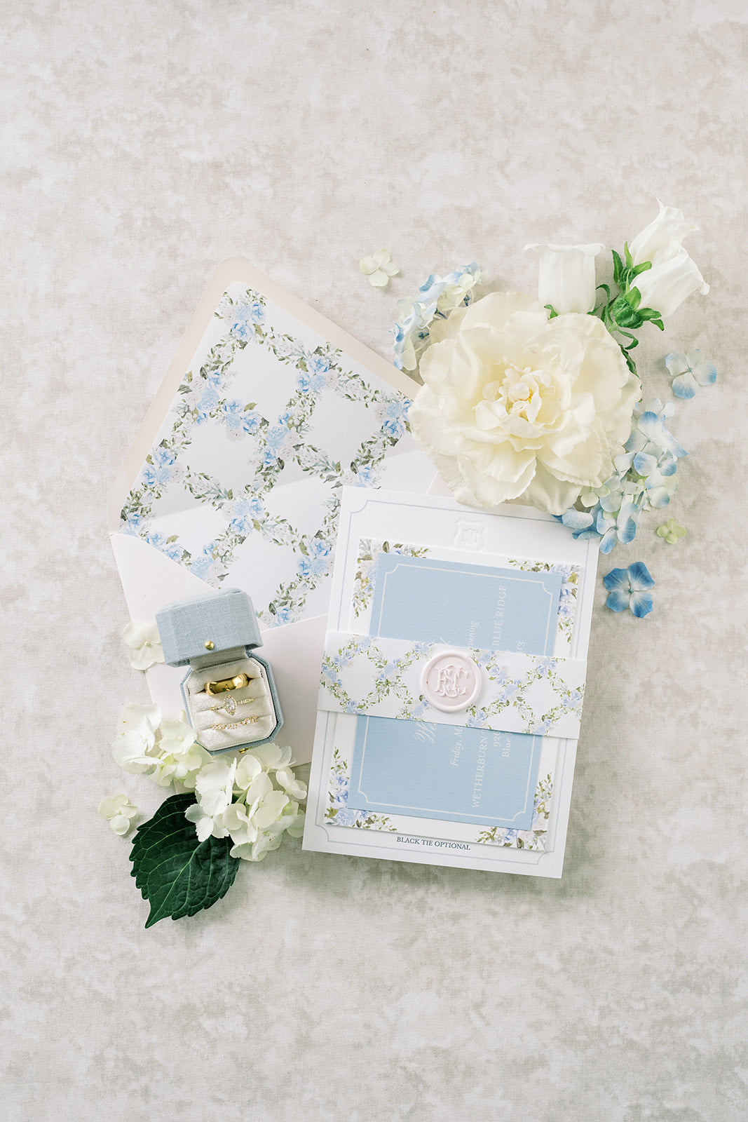 Pale blue invitation flat lay with a Hydrangea Radiant Legacy ring box