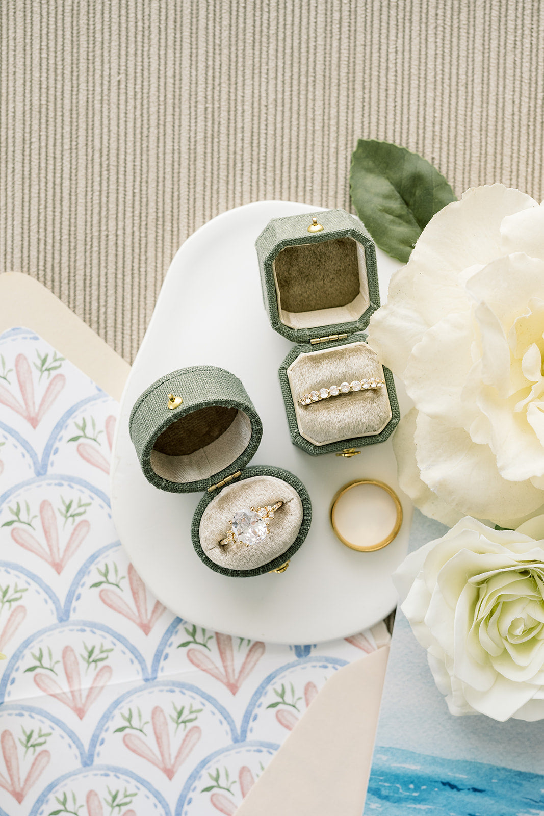 Sage green Georgian oval ring boxes with rings on toile with white roses