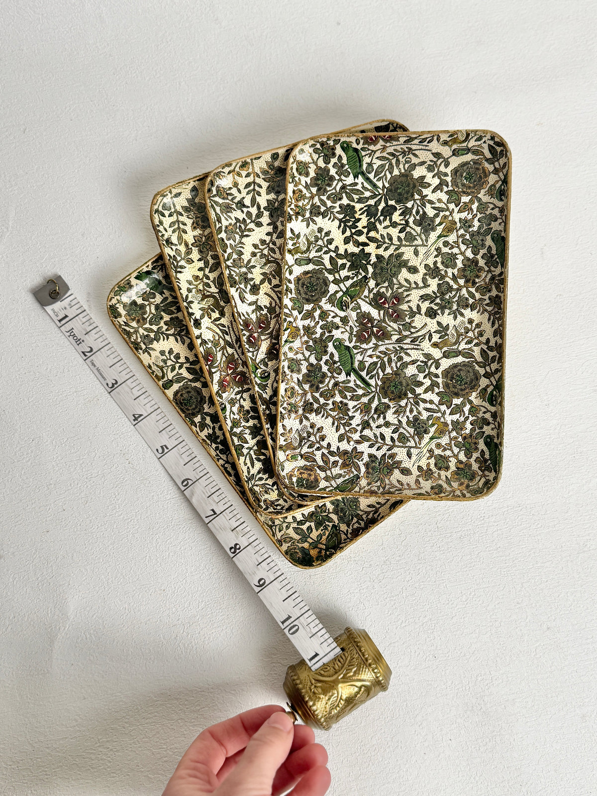 Vintage floral trays measured with a tape measure