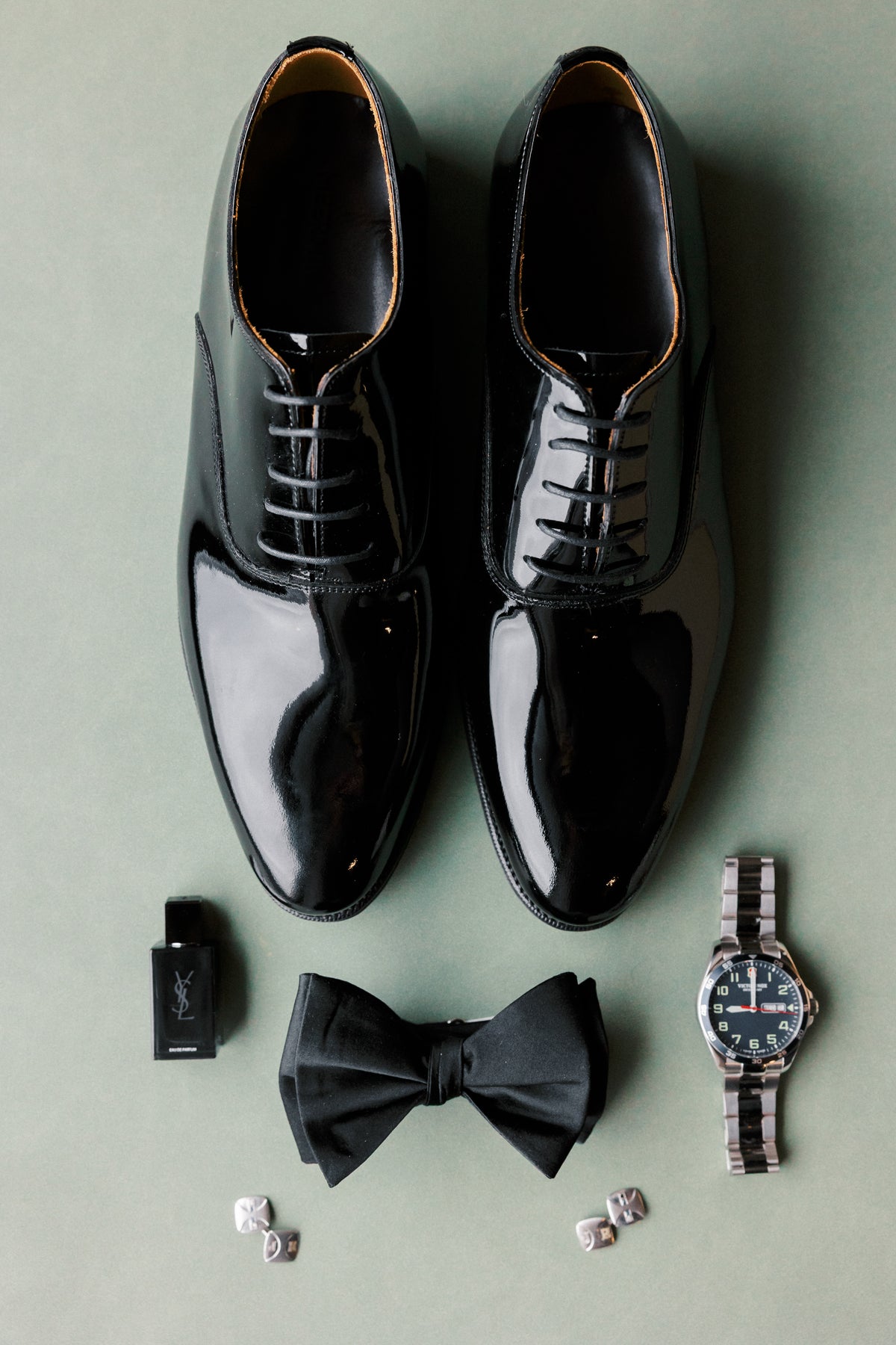 Groom's shoes, bow tie and watch on a Sage suede styling mat