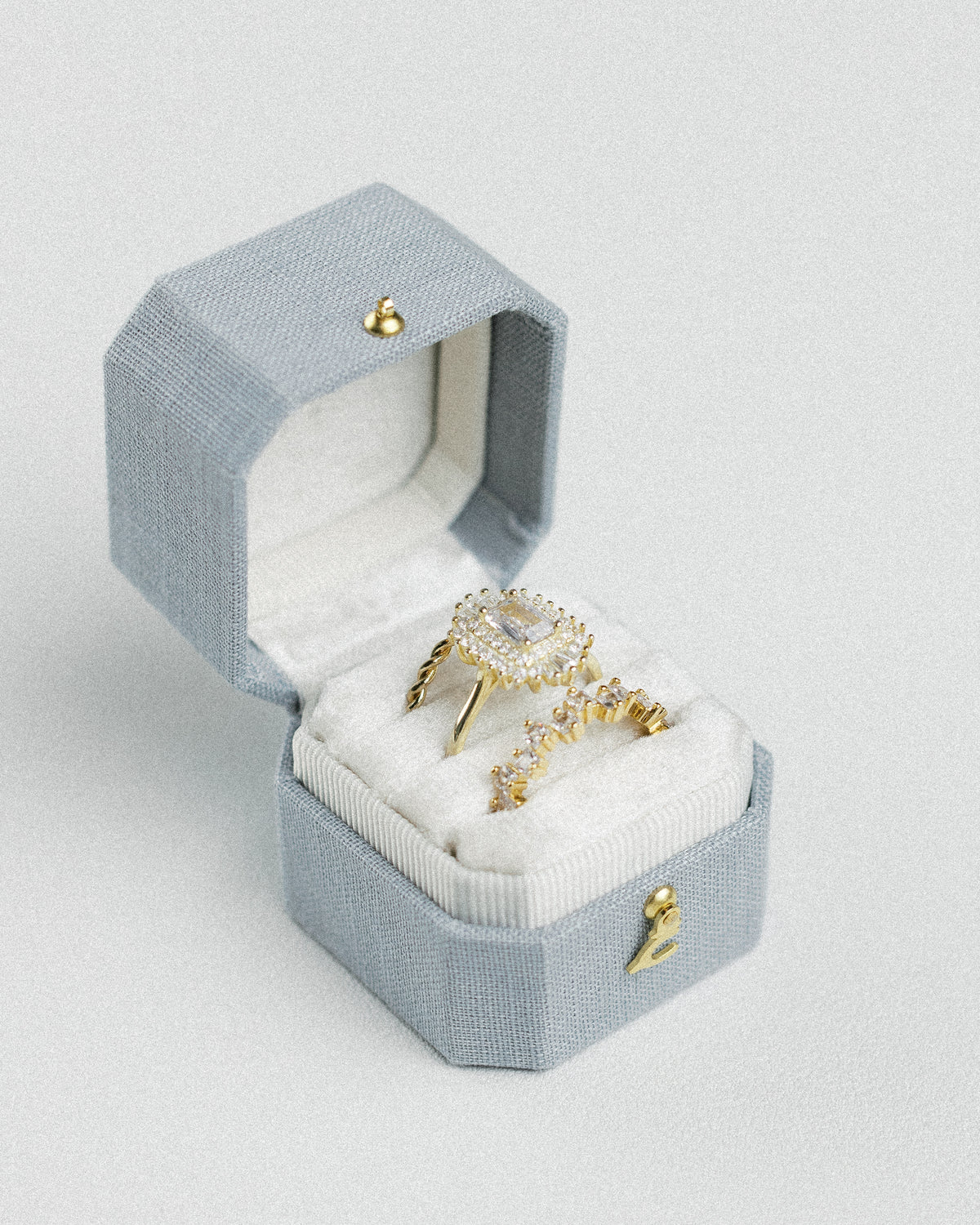Radiant Legacy beveled square ring box in Hydrangea blue linen, open with rings