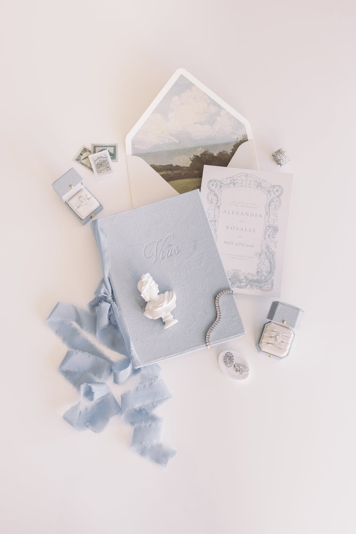 Blue ribbon and invitation flat lay with a Hydrangea Radiant Legacy ring box