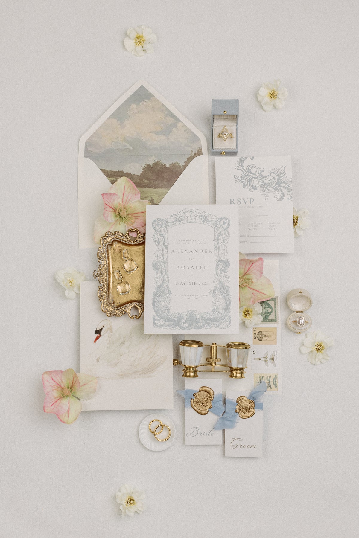 Wedding invitation flat lay with landscape envelope liner, wax seals and a mini white scalloped dish with a ring